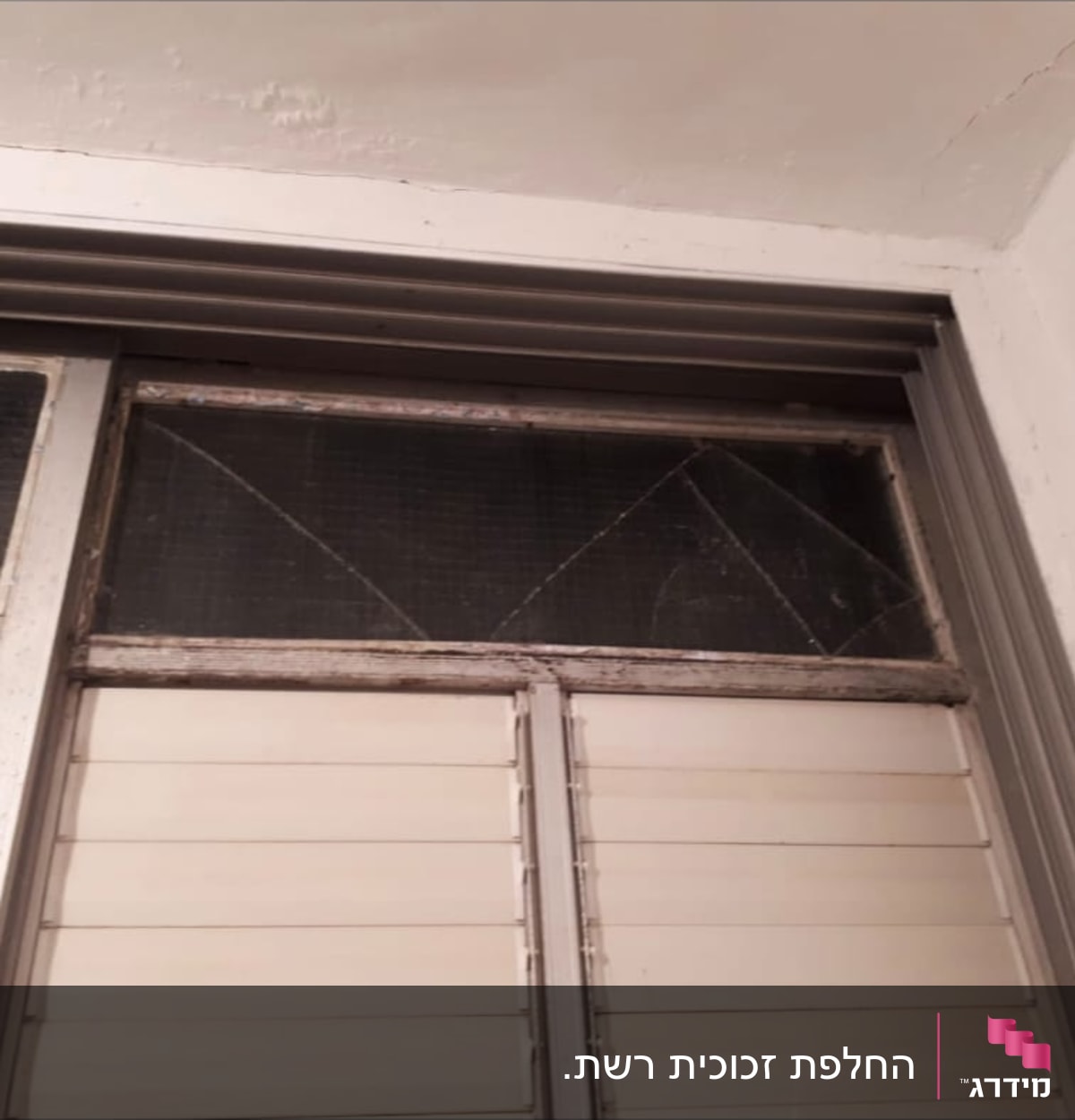חלון עם זכוכית שבורה במסגרת מתכתית